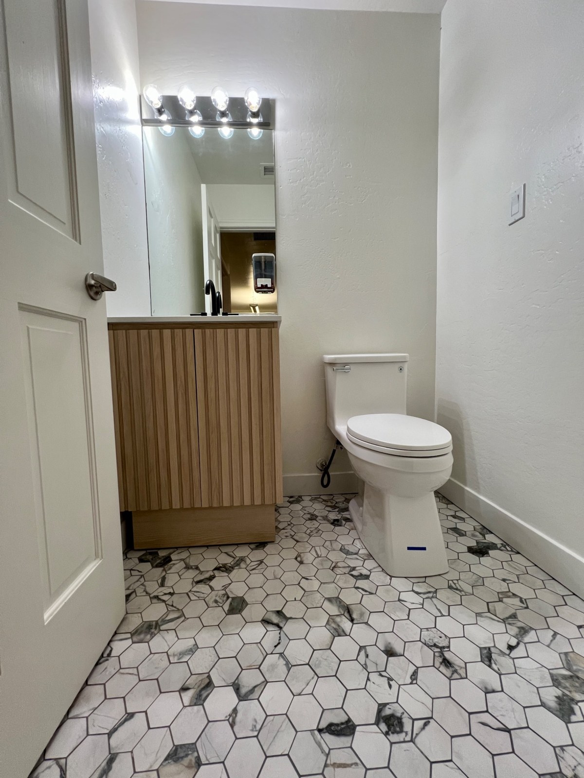 Suite B remodeled bathroom with wood-front vanity and patterned tile